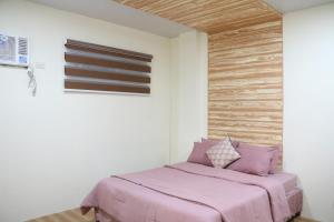 a bedroom with a pink bed in a room at Anicia Guesthouse Rooms in Manila