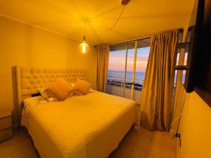 a bedroom with a bed with a view of the ocean at Bello departamento Resort vista al mar in Iquique