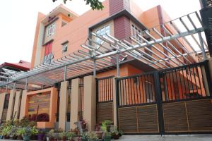 a house with a wooden gate and a fence at Anicia Guesthouse Rooms in Manila