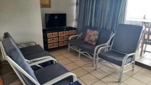 a living room with two chairs and a tv at Dumela Margate Flat No 30 in Margate