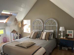 瓦洛涅的住宿－Le 33 Maison de charme coeur Cotentin，一间卧室设有一张大床和两个窗户。