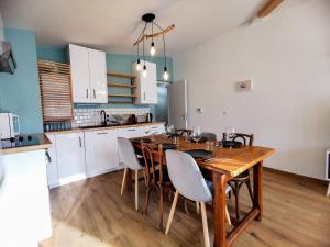 L'AQUAE - Parking - Wifi - Netflix في إيكس لي بان: مطبخ مع طاولة وكراسي خشبية في الغرفة