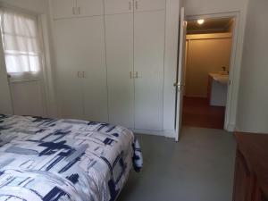 a bedroom with a bed and a bathroom with a sink at Bike Forge Farm Stay in Tulbagh