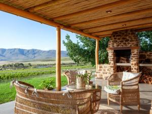 an outdoor patio with a stone fireplace and chairs at Vineyard Cottage in Stanford