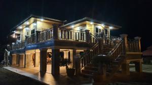 una casa grande con una escalera delante de ella por la noche en บ้านสวนรดา baansuanrada, en Ban Wang Hom
