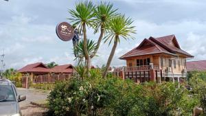 a house with palm trees in front of it at บ้านสวนรดา baansuanrada in Ban Wang Hom