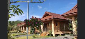 a house with a hanging plant in front of it at บ้านสวนรดา baansuanrada in Ban Wang Hom