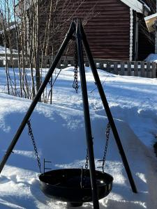 a swing in the snow in a yard at Enok Hytter & Resort in Liagardane