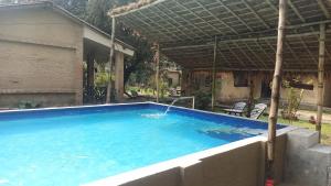 una piscina en un patio con una casa en Tharu Lodge, en Sauraha