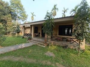 ein Haus mit einem Picknicktisch davor in der Unterkunft Tharu Lodge in Sauraha