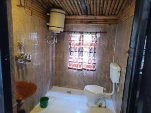 ein Bad mit einem WC und einem Waschbecken in der Unterkunft Tharu Lodge in Sauraha