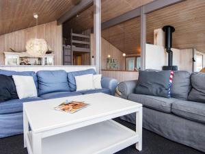 een woonkamer met blauwe banken en een witte tafel bij 10 person holiday home in Henne in Henne