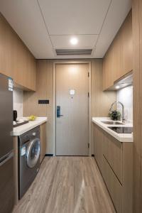eine Küche mit einer Waschmaschine, einem Trockner und einer Tür in der Unterkunft CM Serviced Apartment Shenzhen Dongmen in Shenzhen
