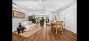 sala de estar con sofá blanco y mesa en Jetty beach shack, en Coffs Harbour