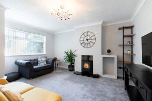 a living room with a couch and a fireplace at One Harp Hill in Cheltenham