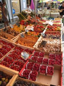 een markt met veel dozen groenten en fruit bij La Petite Cave in Saignon