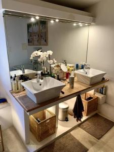 a bathroom with two sinks and a large mirror at La Petite Cave in Saignon