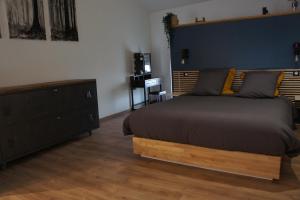 1 dormitorio con 1 cama grande y pared azul en L'espaco, en Saint-Jeure-dʼAy