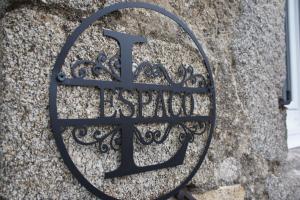 a metal sign on the side of a stone wall at L'espaco in Saint-Jeure-dʼAy
