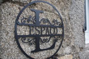 una señal de metal en el costado de una pared de piedra en L'espaco, en Saint-Jeure-dʼAy