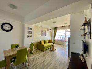 ein Wohnzimmer mit einem grünen Sofa und einem Tisch in der Unterkunft Apartament vedere la mare in Mamaia