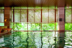 a swimming pool in a room with a large window at Ooedo Onsen Monogatari Premium Kinugawa Kanko Hotel in Nikko