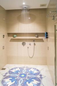 y baño con ducha y alfombra en el suelo. en Ambassador Transit Lounge Terminal 3 en Singapur