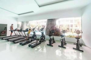 a gym with a row of tread machines in a room at laguna3 pattaya best pool room in Jomtien Beach