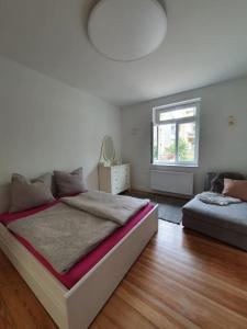 a white bedroom with a bed and a window at EG Weststadt Karlsruhe 4 Zimmer in Karlsruhe