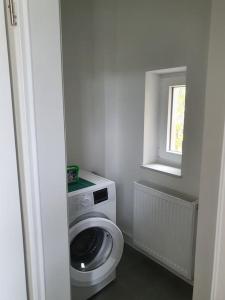 a bathroom with a washing machine and a window at EG Weststadt Karlsruhe 4 Zimmer in Karlsruhe