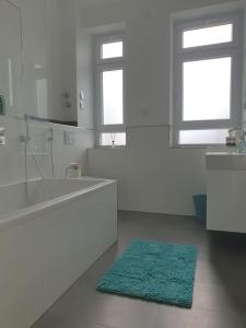 a white bathroom with a green rug on the floor at EG Weststadt Karlsruhe 4 Zimmer in Karlsruhe