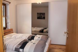 a bedroom with two beds and a mirror at Ferienwohnung Geigelsteinblick in Schleching