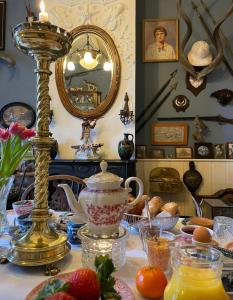 a table with a tea pot and a lamp on it at Deventer Heritage en Boutique B&B museumhuis Huize "De Worp" in Deventer