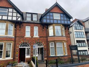 uma casa de tijolos vermelhos com uma casa a preto e branco em The Whalebone Arch em Whitby