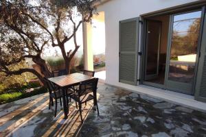 une table et des chaises sur une terrasse avec une fenêtre dans l'établissement Admonis - Home in the olive grove, à Melissátika