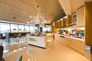 uma grande cozinha com um balcão e uma área de refeições em Ambassador Transit Lounge Terminal 2 em Singapura
