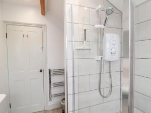 a bathroom with a shower with a glass door at Canny Cottage in Belford +28 photos