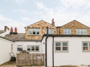 a detached house with a white exterior at Canny Cottage in Belford