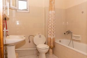 een badkamer met toilet, wastafel en bad bij vickys family house in Stavros +35 foto's