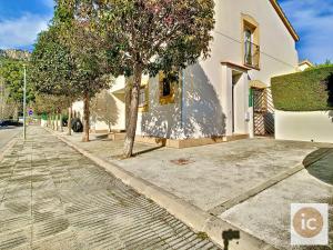 a tree on a sidewalk next to a building at La Vela Estartit Rental in L'Estartit