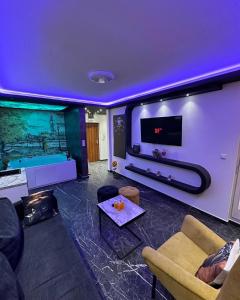 ein Wohnzimmer mit einem Sofa und einem TV in der Unterkunft Apartman S&V 3 Istocno Sarajevo Lukavica sa Jacuzzi Lux Spa Hilandarska Centar in Lukavica