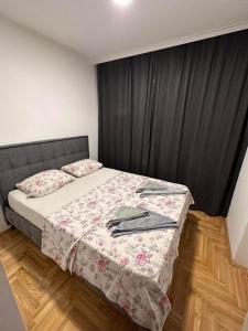 ein kleines Schlafzimmer mit einem Bett mit einem schwarzen Vorhang in der Unterkunft Apartman S&V 3 Istocno Sarajevo Lukavica sa Jacuzzi Lux Spa Hilandarska Centar in Lukavica