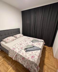 ein Schlafzimmer mit einem Bett mit einem schwarzen Vorhang in der Unterkunft Apartman S&V 3 Istocno Sarajevo Lukavica sa Jacuzzi Lux Spa Hilandarska Centar in Lukavica