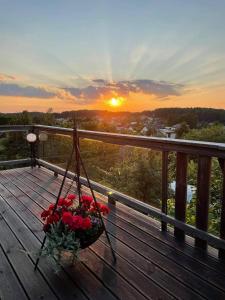 a basket of flowers on a deck with the sunset at ODM&A apartment in Vilnius