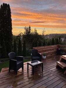 a deck with chairs and a table and a sunset at ODM&A apartment in Vilnius