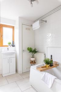 a white bathroom with a tub and a sink at Levi Suite by Koya Homes in Cardiff