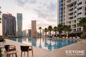 a large swimming pool in a city with tall buildings at KeyOne - Studio in DAMAC Maison Privé in Dubai