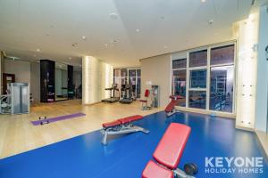 a gym with a blue floor and red chairs at KeyOne - Studio in DAMAC Maison Privé in Dubai