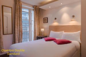 1 dormitorio con 1 cama blanca grande con almohadas rojas en Hôtel Gaillon Opera, en París