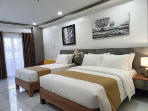 a hotel room with two beds in a room at Rosh Hotel in Manila